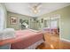Bedroom featuring hardwood floors, ceiling fan, sliding mirrored closet and a view of the lake at 7115 Lake Ola Dr, Mount Dora, FL 32757