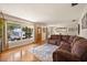 Bright living room features hardwood floors, a comfortable sectional couch, and a view of the lake at 7115 Lake Ola Dr, Mount Dora, FL 32757