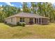 Back exterior view of the home showing the screened lanai and spacious yard at 814 Olive Ave, Fruitland Park, FL 34731