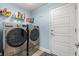 Well-equipped laundry room with modern front-load washer and dryer, shelving, and ample space at 814 Olive Ave, Fruitland Park, FL 34731