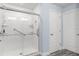 Accessible shower with grab bars, tile surround, and a sliding glass door for safety at 814 Olive Ave, Fruitland Park, FL 34731
