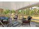 Enclosed sunroom featuring wicker furniture, blue accents and serene views of the landscaped yard at 814 Olive Ave, Fruitland Park, FL 34731