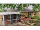 Backyard with screened porch, brick patio, and garden beds provide a relaxing outdoor space at 831 Whisper Sound, Minneola, FL 34715