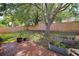 Backyard with brick patio, garden beds, mature tree, and tall wooden fence for privacy at 831 Whisper Sound, Minneola, FL 34715