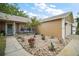 Front yard with decorative rock garden, mature plants, and covered entryway at 831 Whisper Sound, Minneola, FL 34715