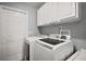 A laundry room featuring a washer, dryer and overhead cabinets at 831 Whisper Sound, Minneola, FL 34715