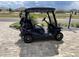 Pictured is a blue golf cart with golf clubs parked on the paver driveway of this single-Gathering home at 8433 Sw 98Th Terrace Rd, Ocala, FL 34481