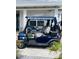 A blue golf cart is parked on the paver driveway of this single-Gathering home at 8433 Sw 98Th Terrace Rd, Ocala, FL 34481