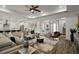 Spacious living room featuring a large sectional sofa, tray ceilings, and wood floors at 8433 Sw 98Th Terrace Rd, Ocala, FL 34481