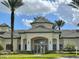 Beautiful clubhouse with a tiled roof, lush landscaping, and a grand entrance at 8815 Dunes Ct # 105, Kissimmee, FL 34747