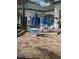 Outdoor patio area with tables, chairs, blue umbrellas, and a stone floor at 8815 Dunes Ct # 105, Kissimmee, FL 34747