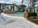 Resort-style pool with lounge chairs, palm trees, and lush landscaping; perfect for relaxation and recreation at 8815 Dunes Ct # 105, Kissimmee, FL 34747