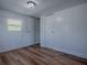 Bright bedroom featuring wood-look flooring, white walls, and a window letting in natural light at 8901 Se 144Th Ln, Summerfield, FL 34491