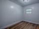 Bright bedroom featuring wood-look flooring, white walls, and a window letting in natural light at 8901 Se 144Th Ln, Summerfield, FL 34491