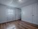 A bright bedroom with wood-look flooring, white walls, and a window dressed with patterned curtains at 8901 Se 144Th Ln, Summerfield, FL 34491