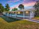Inviting single-story home featuring a covered porch and well-maintained lawn at 8901 Se 144Th Ln, Summerfield, FL 34491