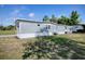View of a single-story home features a side lawn and blue skies in the background at 8901 Se 144Th Ln, Summerfield, FL 34491
