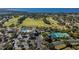 Aerial view of a community featuring a pool, clubhouse, tennis courts, and a golf course near the water at 1001 Harmony Ln, Clermont, FL 34711