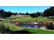 Scenic view of the golf course with a small pond, lush greenery, and the word 'LEGENDS' on the hill at 1001 Harmony Ln, Clermont, FL 34711