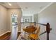 Hallway featuring hardwood floors and a table with chairs, with a peek into an adjacent bedroom at 1001 Harmony Ln, Clermont, FL 34711