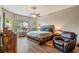 Main bedroom with hardwood floors, fan, large window, and comfortable seating area at 1001 Harmony Ln, Clermont, FL 34711