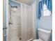 Bright bathroom featuring shower with curtain, toilet, and window at 1003 Parker Pl, Lady Lake, FL 32159