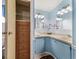 Cozy bathroom with charming blue cabinets, double sinks, and decor at 1003 Parker Pl, Lady Lake, FL 32159