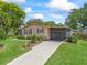 Inviting single-story home with a well-maintained lawn, mature trees, and a charming screened-in porch at 1003 Parker Pl, Lady Lake, FL 32159