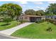Charming single-story home with well-maintained lawn, mature trees and inviting screened-in porch in a sunny setting at 1003 Parker Pl, Lady Lake, FL 32159