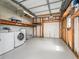 Garage interior features washer and dryer, white walls, shelves, and a roll-up door at 1003 Parker Pl, Lady Lake, FL 32159