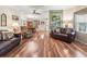 Open-concept living room featuring hardwood floors and comfortable leather furniture at 1003 Parker Pl, Lady Lake, FL 32159