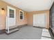 Enclosed patio area features concrete flooring, a roll-up door, and access to the main house through a white door at 1003 Parker Pl, Lady Lake, FL 32159