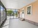 Enclosed lanai area offers screened windows with views of the home's exterior, and access to home via a door with steps at 1003 Parker Pl, Lady Lake, FL 32159