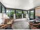 Sunroom with tile flooring features cushioned wicker furniture, curtains and views of the backyard at 1003 Parker Pl, Lady Lake, FL 32159