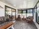 Sunroom with tile flooring features cushioned wicker furniture and sliding door access to another area of the house at 1003 Parker Pl, Lady Lake, FL 32159