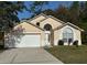 Charming one-story home featuring an attached two-car garage, arched windows, and a well-maintained lawn at 1040 Soaring Eagle Ln, Kissimmee, FL 34746