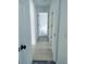 Hallway with neutral tile flooring leads to an adjacent room with modern gray wood-look floors at 1040 Soaring Eagle Ln, Kissimmee, FL 34746