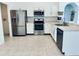 Modern kitchen with stainless steel appliances, white cabinets, and a tiled floor at 1040 Soaring Eagle Ln, Kissimmee, FL 34746