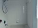 All-white tiled shower and bath with chrome fixtures at 1040 Soaring Eagle Ln, Kissimmee, FL 34746