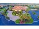 Stunning aerial view of community clubhouse featuring lush landscaping, a fountain, and ample parking at 10460 Silver Maple Ave, Oxford, FL 34484