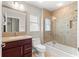 Updated bathroom showcasing vanity, toilet, and bathtub/shower combination with decorative tile surround at 10460 Silver Maple Ave, Oxford, FL 34484
