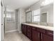Bathroom featuring double sink vanity, tile flooring, and glass block window at 10460 Silver Maple Ave, Oxford, FL 34484