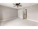 Bedroom featuring neutral carpet, ceiling fan, closet, and a doorway to the bathroom at 10460 Silver Maple Ave, Oxford, FL 34484