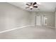Bright, carpeted bedroom with ceiling fan and neutral wall paint at 10460 Silver Maple Ave, Oxford, FL 34484