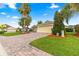 Charming single-story home with brick-paved driveway, lush lawn, and well-manicured landscaping in a friendly neighborhood at 10460 Silver Maple Ave, Oxford, FL 34484