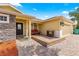Welcoming single-story home with a brick-paved patio with furniture and a well-manicured lawn at 10460 Silver Maple Ave, Oxford, FL 34484