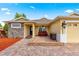 Inviting single-story home with a brick-paved patio featuring outdoor seating and stone detailing at 10460 Silver Maple Ave, Oxford, FL 34484