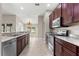 Modern kitchen featuring stainless steel appliances, granite countertops, and dark wood cabinetry at 10460 Silver Maple Ave, Oxford, FL 34484