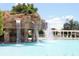 Resort-style pool featuring a stunning rock waterfall and a bright blue sky for a luxurious outdoor experience at 10460 Silver Maple Ave, Oxford, FL 34484