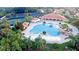 Aerial view of a community pool area surrounded by lush greenery and recreational amenities at 10460 Silver Maple Ave, Oxford, FL 34484